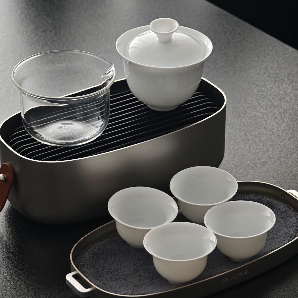 Travel gaiwan and pitcher above the case with four cups on the lid