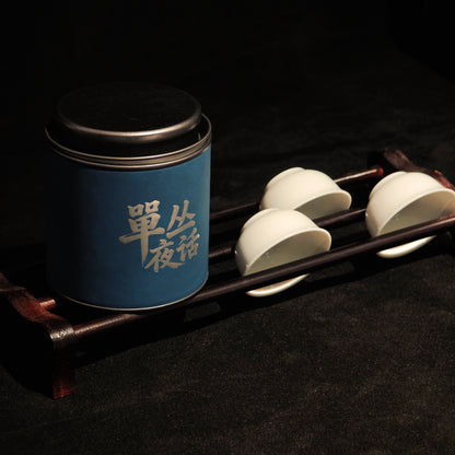 Blue Ya Shi Xiang tea tin beside a white gaiwan