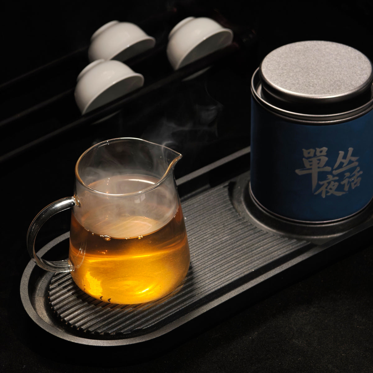 Glass of brewed tea beside the Ya Shi Xiang tin