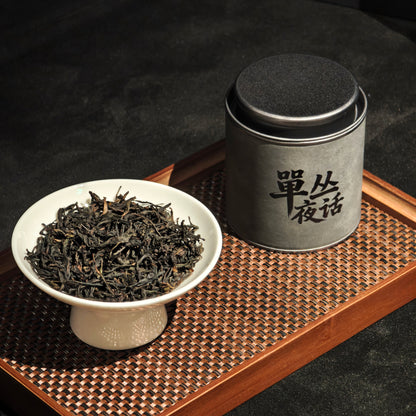 Honey Orchid Dancong tea tin beside loose leaves in a bowl