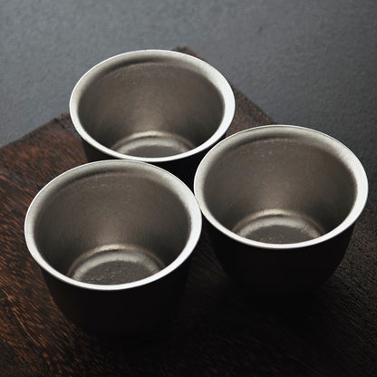Three matching titanium tasting cups