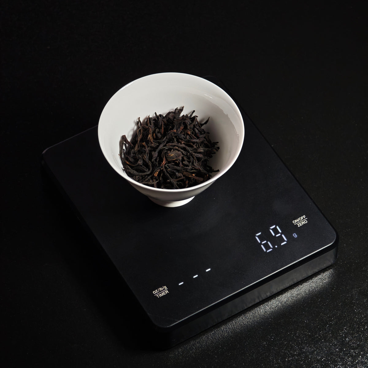Loose-leaf tea in a bowl on the digital scale
