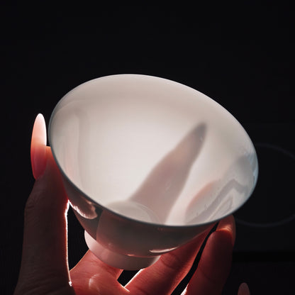 White gaiwan held toward the light