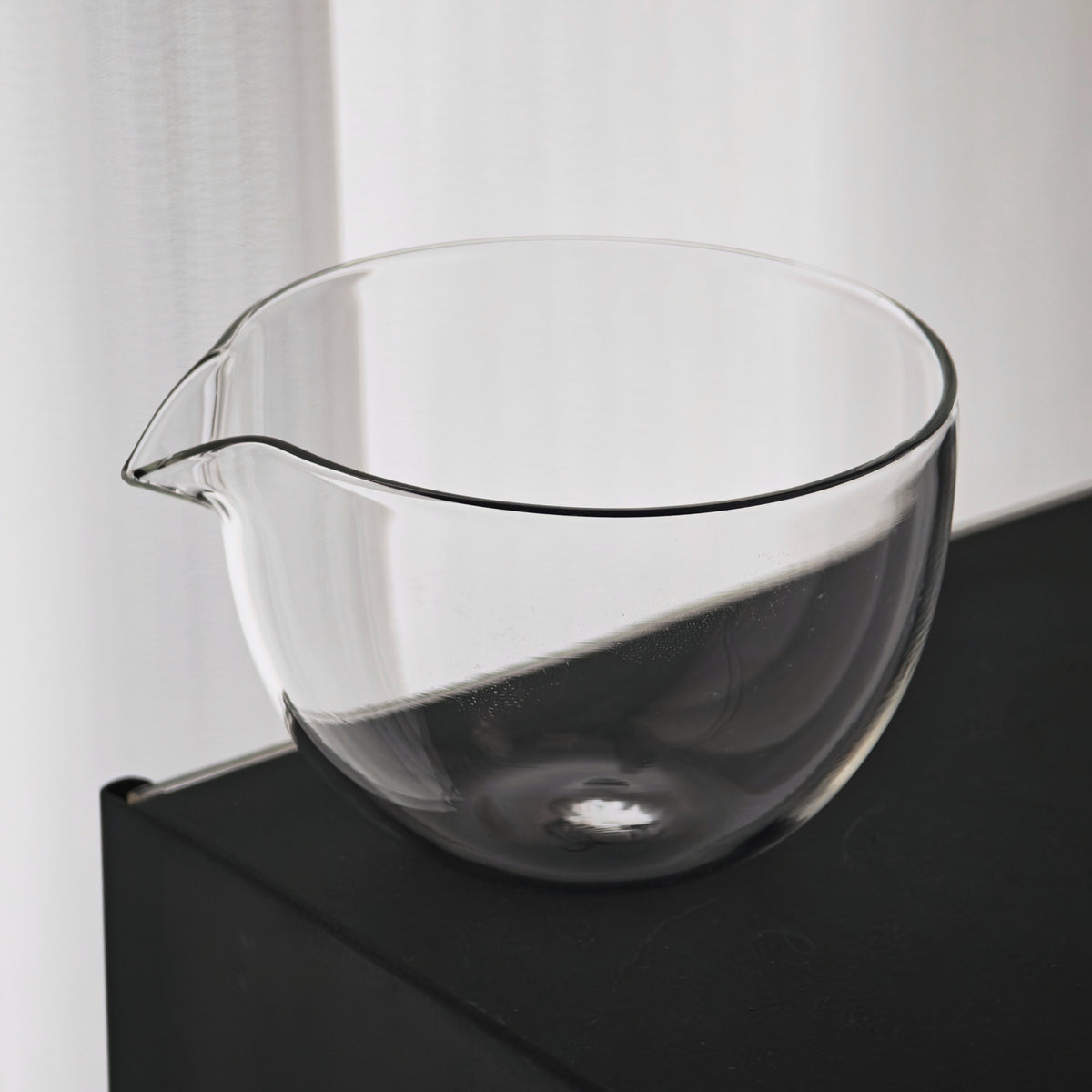 Clear glass tea pitcher viewed from an angle