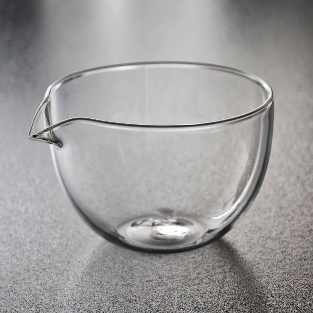 Empty handleless glass tea pitcher with shaped spout
