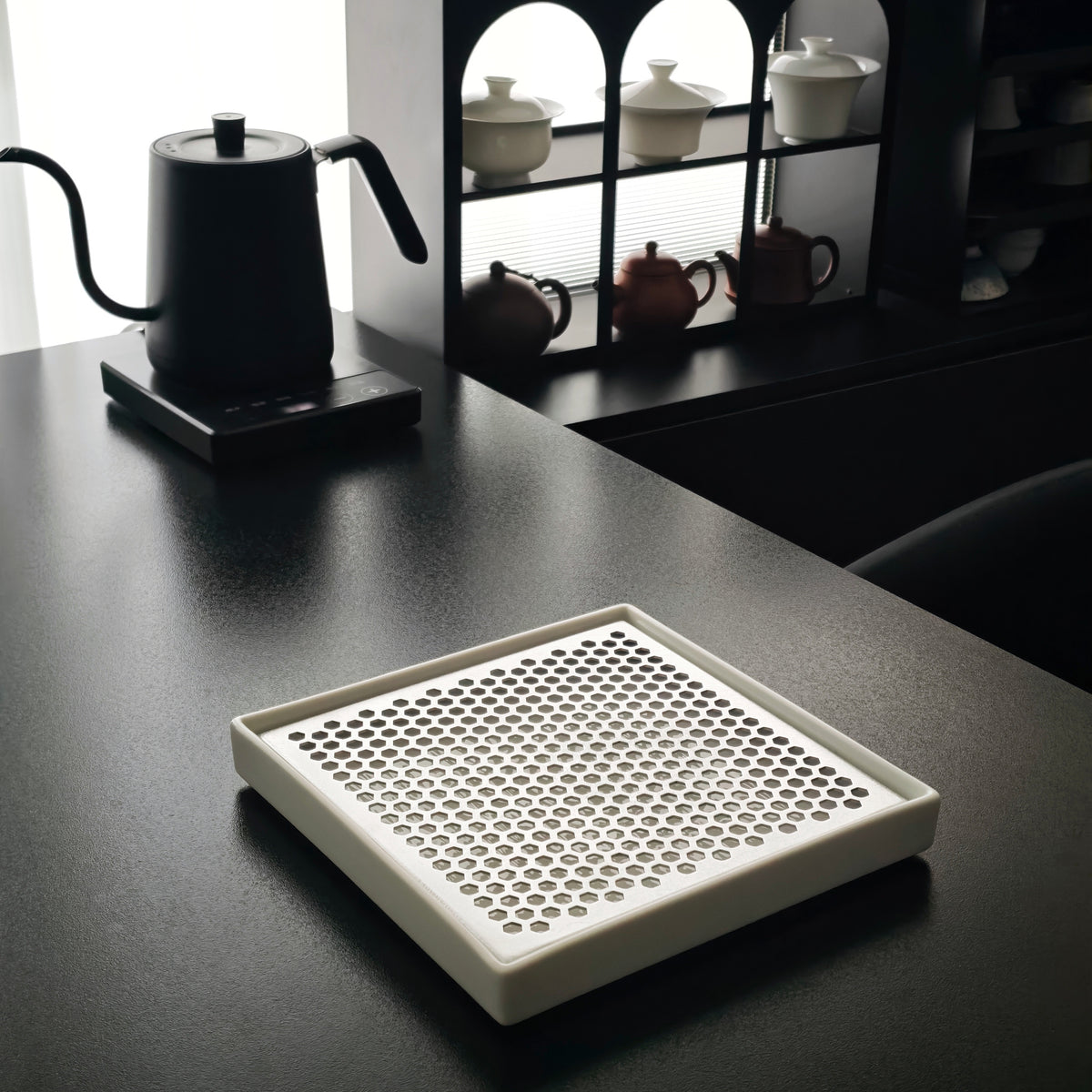 White porcelain tea tray on a table beside a kettle
