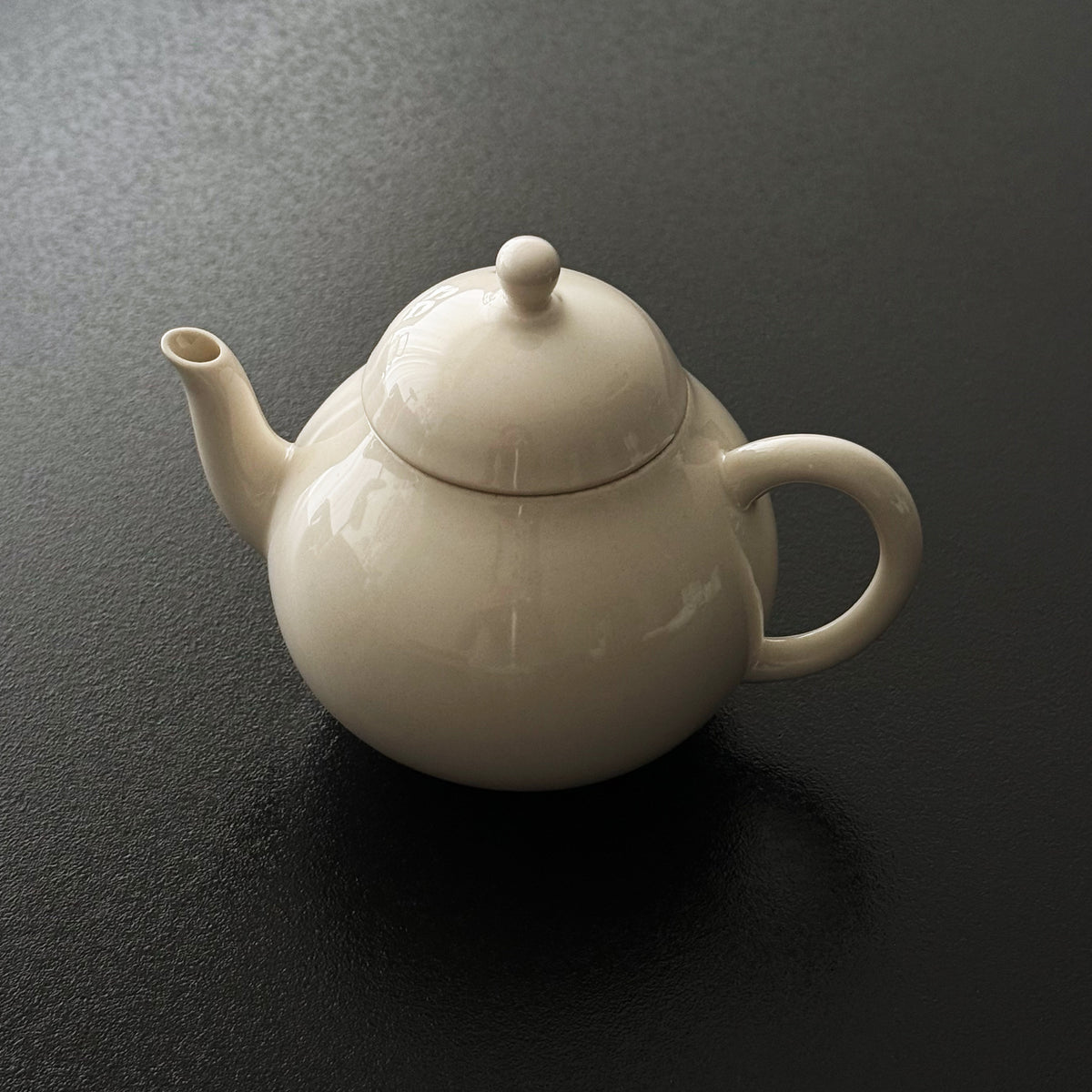 Rounded ash-glazed ceramic teapot with matching lid